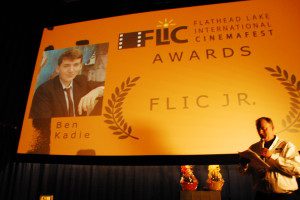 Daniel Smith in front of the movie screen announcement of Ben Kadie as FLIC Jr. winner.